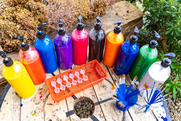 A photograph of a table showcasing various easily accessible crafting supplies like colorful plastic bottles, clean cardboard boxes, a roll of duct tape, scissors, a marker, and a non-toxic glue stick, ready to be used for creating a DIY pet puzzle feeder.