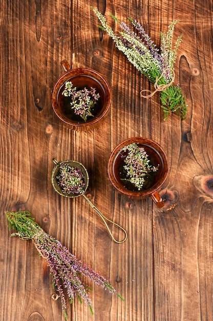 A detailed shot of various dried herbs commonly used in flea collars, such as lavender, cedar, rosemary, and peppermint. The herbs are arranged artfully on a wooden surface.