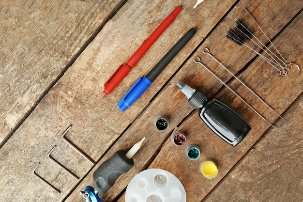 A detailed shot of an array of tools and materials laid out on a workbench, including a handsaw, drill, measuring tape, various types of screws, nails, lengths of untreated wood, and birdseed in a clear container.