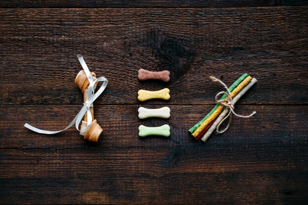 A cardboard box filled with puppy toys, food bowls, a collar, and a leash, arranged neatly on a wooden floor, showcasing essential puppy supplies.